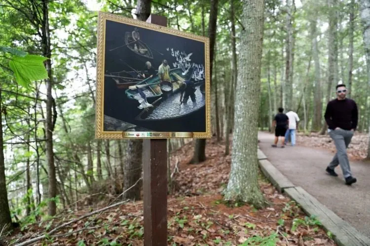 A reproduction of “Dark Harbor Fishermen” by N.C. Wyeth is posted along a trail in Wolfe’s Neck Woods State Park in Freeport. The Portland Museum of Art has partnered with L.L. Bean and the state parks bureau to install reproductions of 25 works of art from its permanent collections at five outdoor sites this summer. Ben McCanna/Staff Photographer